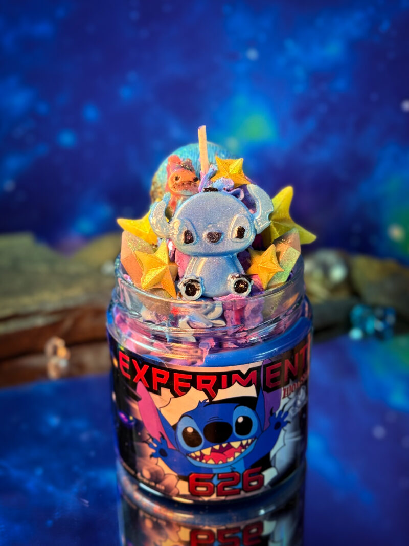 Vela literaria artesanal inspirada en Lilo y Stitch, decorada con frosting galáctico y elementos espaciales. Experimento 626.