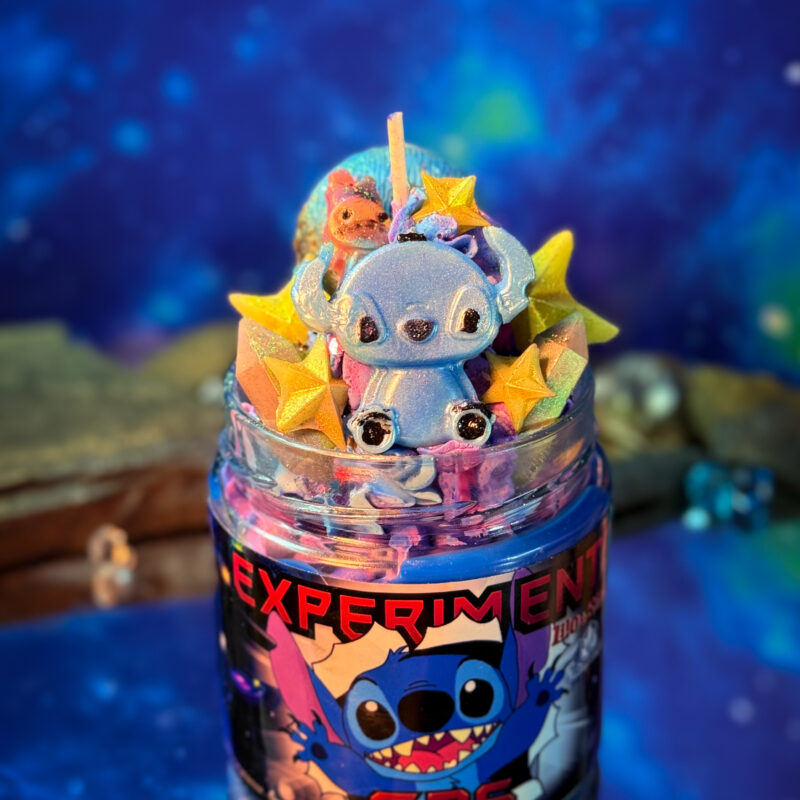 Vela literaria artesanal inspirada en Lilo y Stitch, decorada con frosting galáctico y elementos espaciales. Experimento 626.